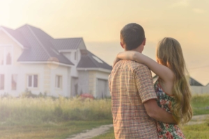 Couple standing in front of new home